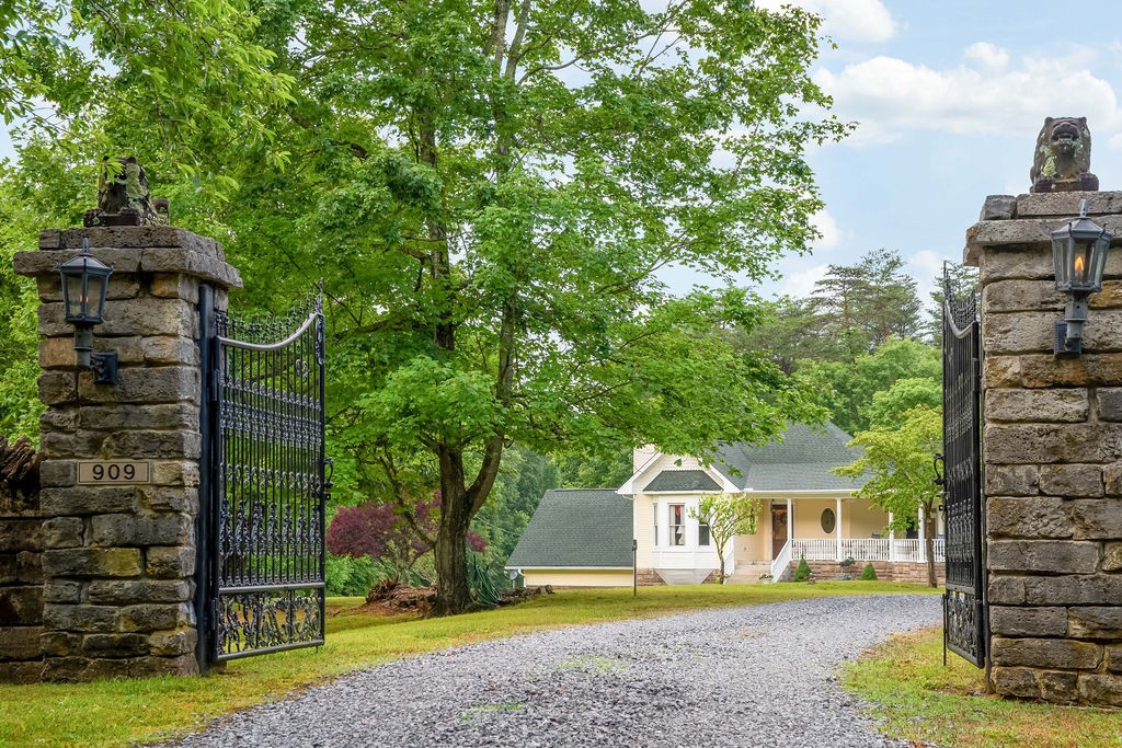a front view of a house with a garden and trees