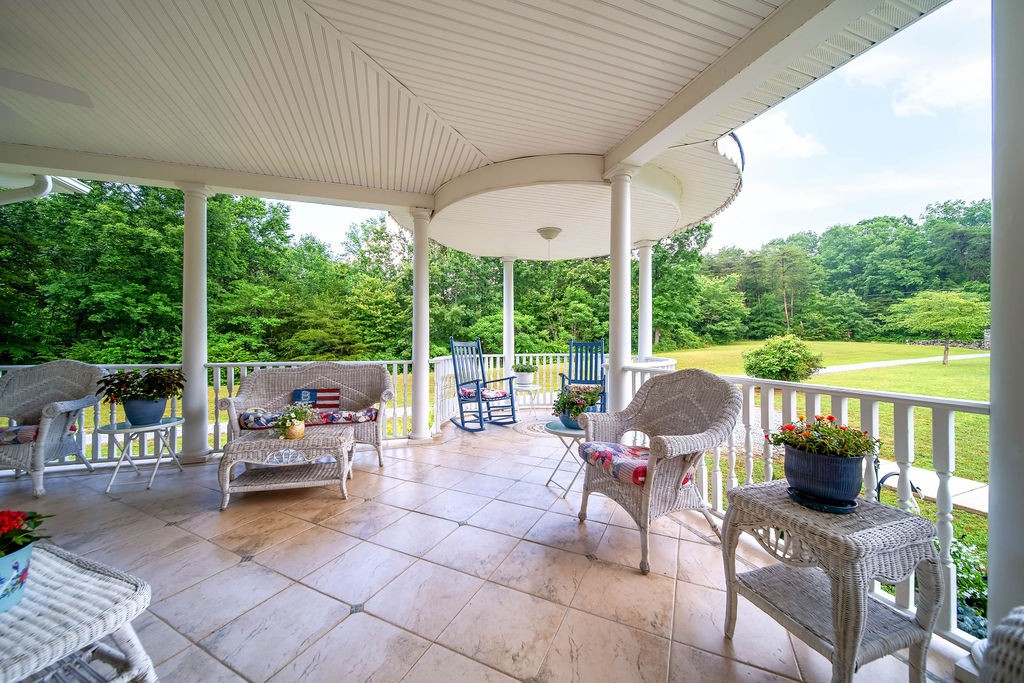 909 Williamson County Line Road Fairview, TN 37062 - Photo 17 of 66 a view of a patio with a dining table and chairs next to a yard