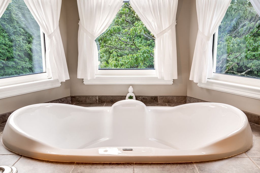 909 Williamson County Line Road Fairview, TN 37062 - Photo 30 of 66 a white bath tub sitting in a bathroom next to a window