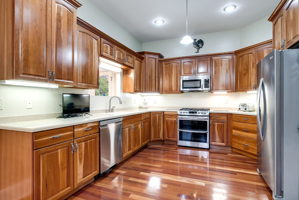 909 Williamson County Line Road Fairview, TN 37062 - Photo 38 of 66 a kitchen with kitchen island granite countertop wooden cabinets a stove a oven and a refrigerator with wooden floor