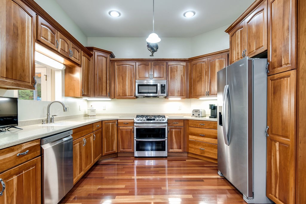 909 Williamson County Line Road Fairview, TN 37062 - Photo 39 of 66 a kitchen with stainless steel appliances granite countertop a refrigerator a sink dishwasher a stove top oven a kitchen island and chairs with wooden floor