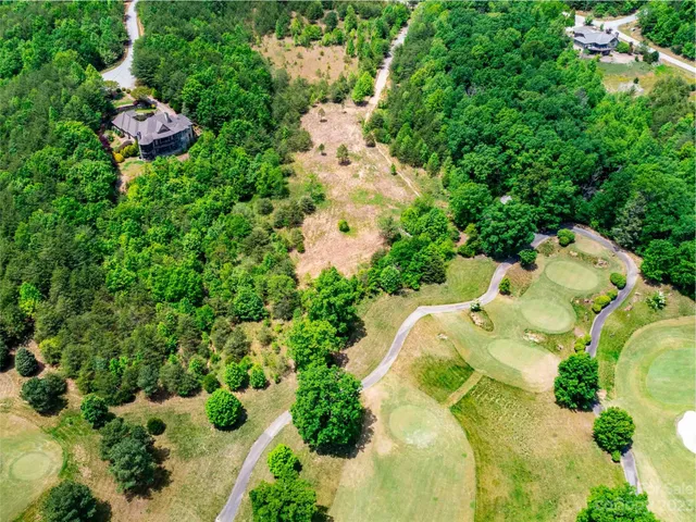 an aerial view of residential house with outdoor space and trees all around