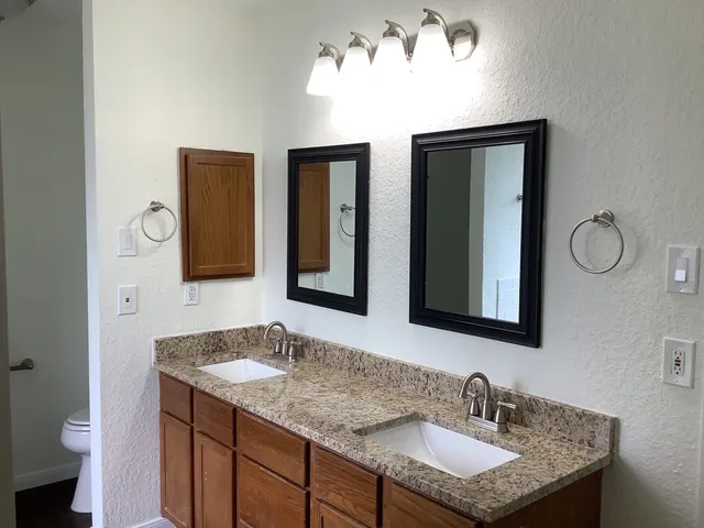 a bathroom with a granite countertop sink and a mirror