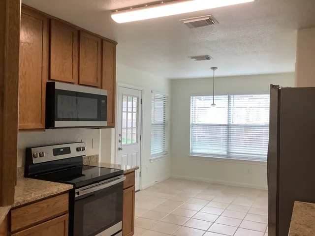 a kitchen with granite countertop a stove and a microwave