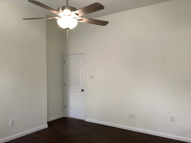a view of a small space with wooden floor and a ceiling fan