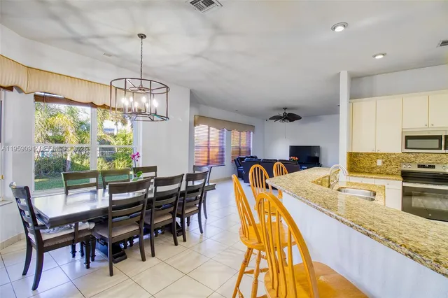 a view of a dining room and livingroom with furniture wooden floor a chandelier