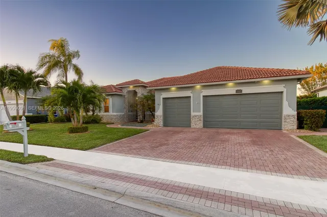 front view of house with a yard and palm trees