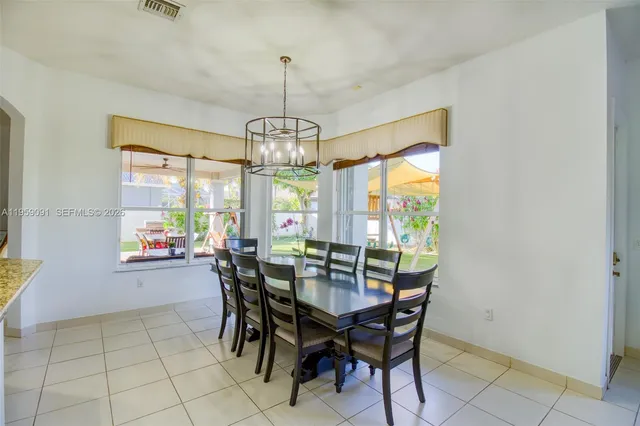 a living room with furniture kitchen view and a large window