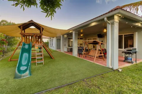 a view of a house with backyard sitting area and garden