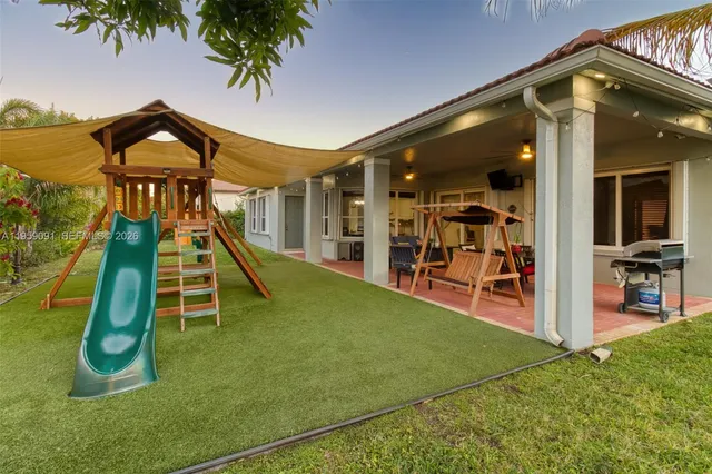 a view of a house with backyard sitting area and garden