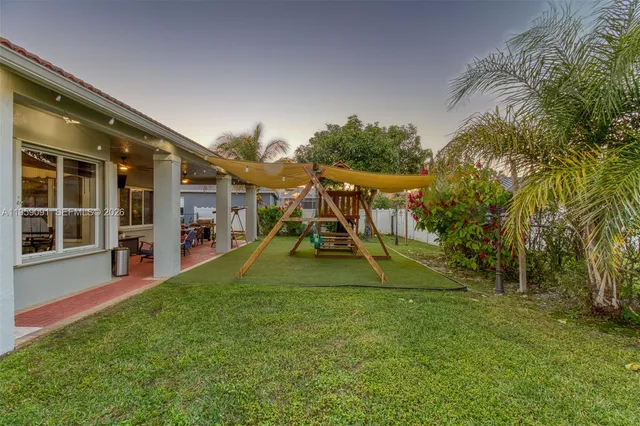 a kitchen with granite countertop a dining table chairs stainless steel appliances and cabinets