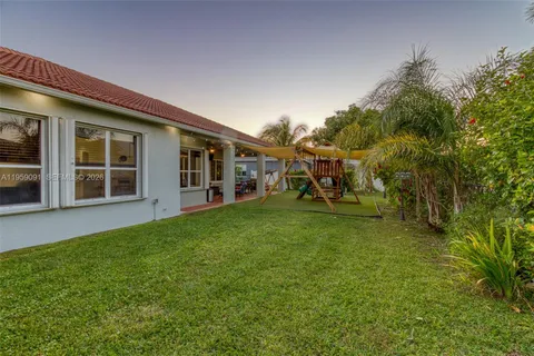 a kitchen with granite countertop a sink stainless steel appliances and white cabinets