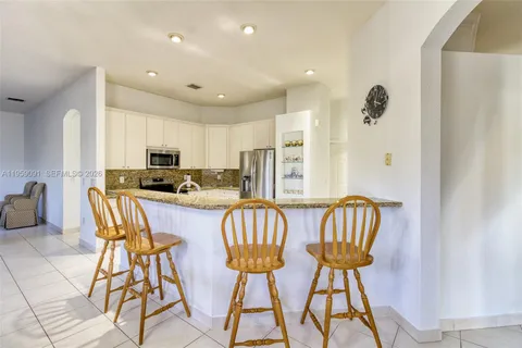 a kitchen with granite countertop a sink stove and refrigerator