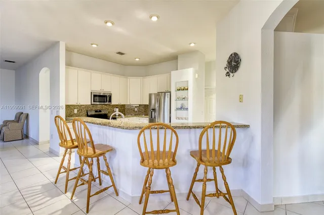 a kitchen with granite countertop a sink stove and refrigerator