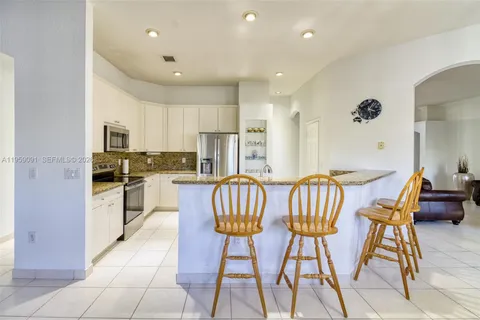 a kitchen with stainless steel appliances granite countertop a refrigerator and a stove