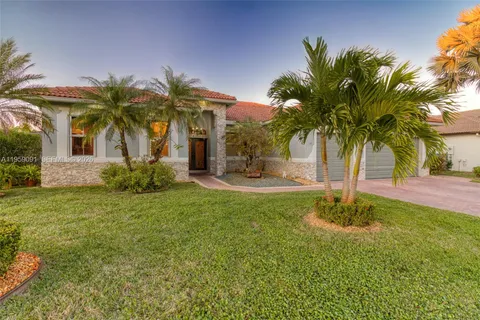 a palm tree sitting in front of a house with a big yard