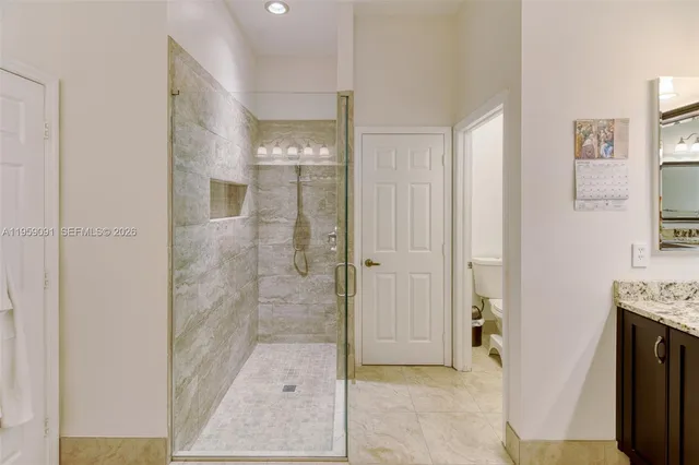 a bathroom with a granite countertop sink toilet and shower