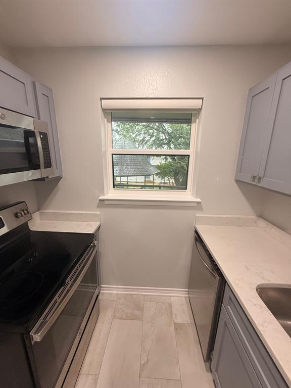 3933 Inwood Road, Unit 2025 Dallas, TX 75209 - Photo 7 of 26 a kitchen that has a sink wooden cabinets and a stove top oven