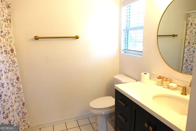 a bathroom with a granite countertop sink toilet and a mirror