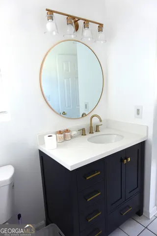 a bathroom with a sink mirror vanity and toilet
