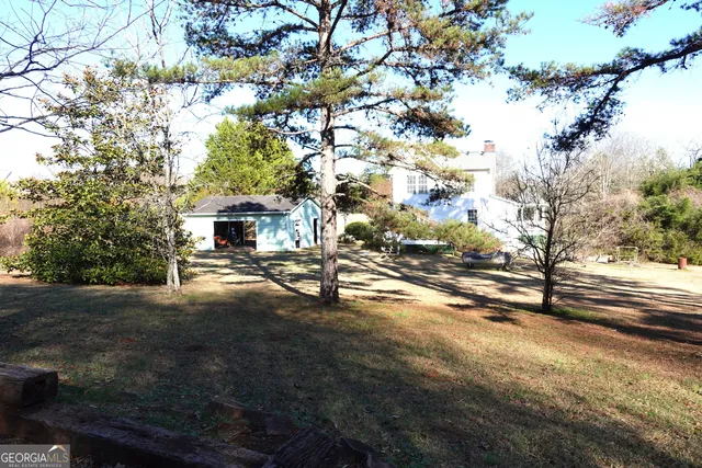 a view of a house with backyard and trees