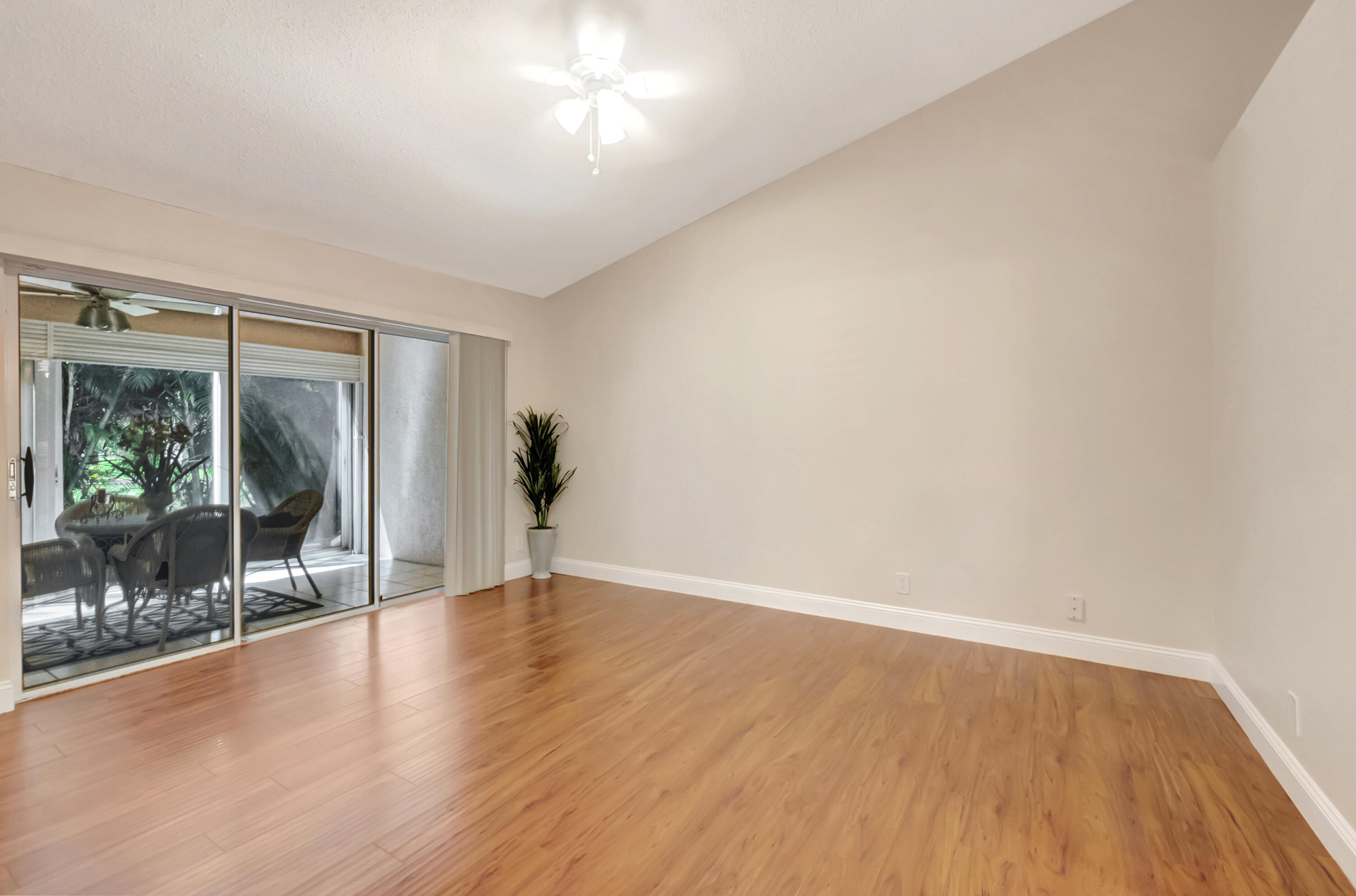 11128 Rios Road Boca Raton, FL 33498 - Photo 20 of 45 a view of an empty room with wooden floor and a window