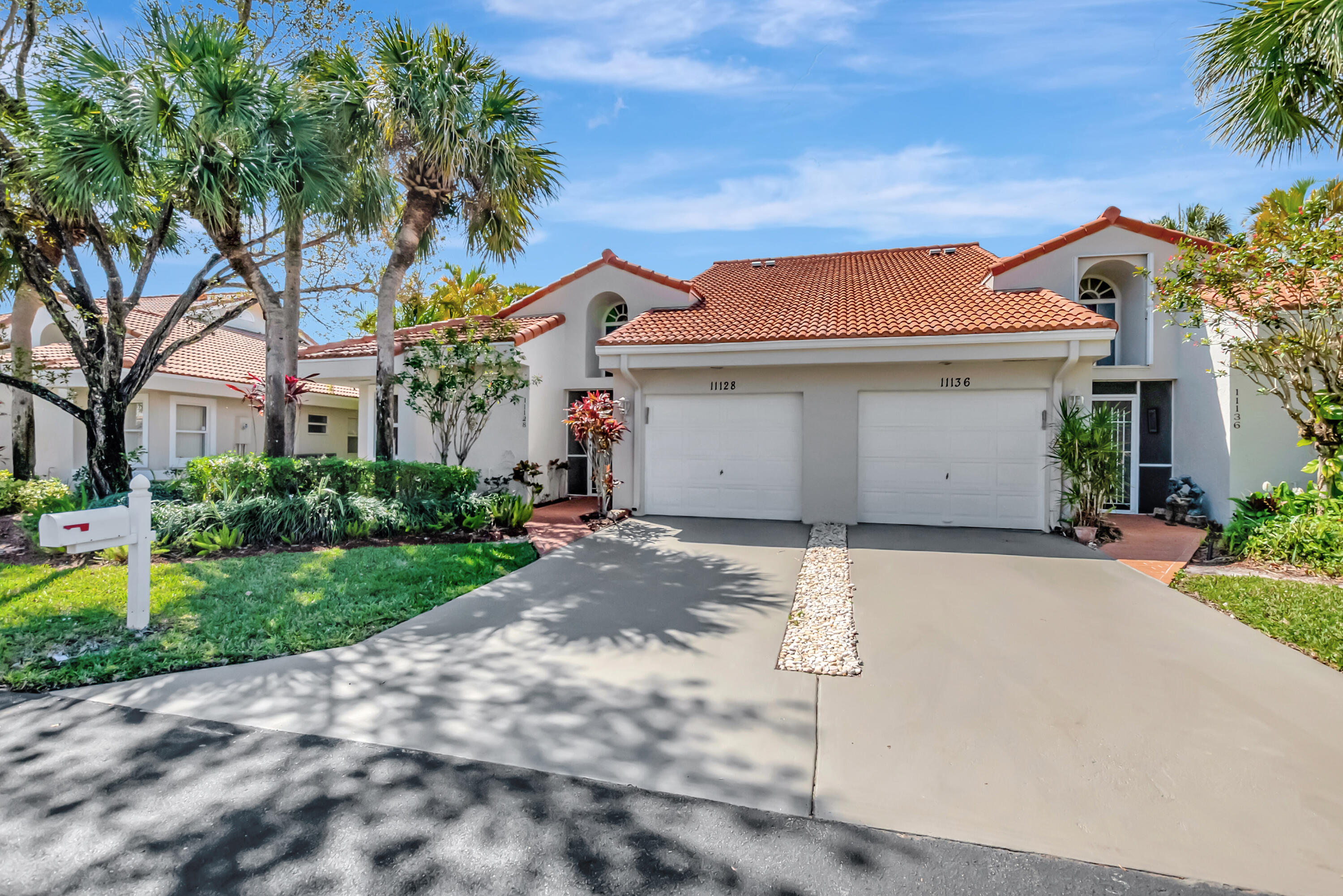 11128 Rios Road Boca Raton, FL 33498 - Photo 3 of 45 a view of a white house with a yard and palm trees