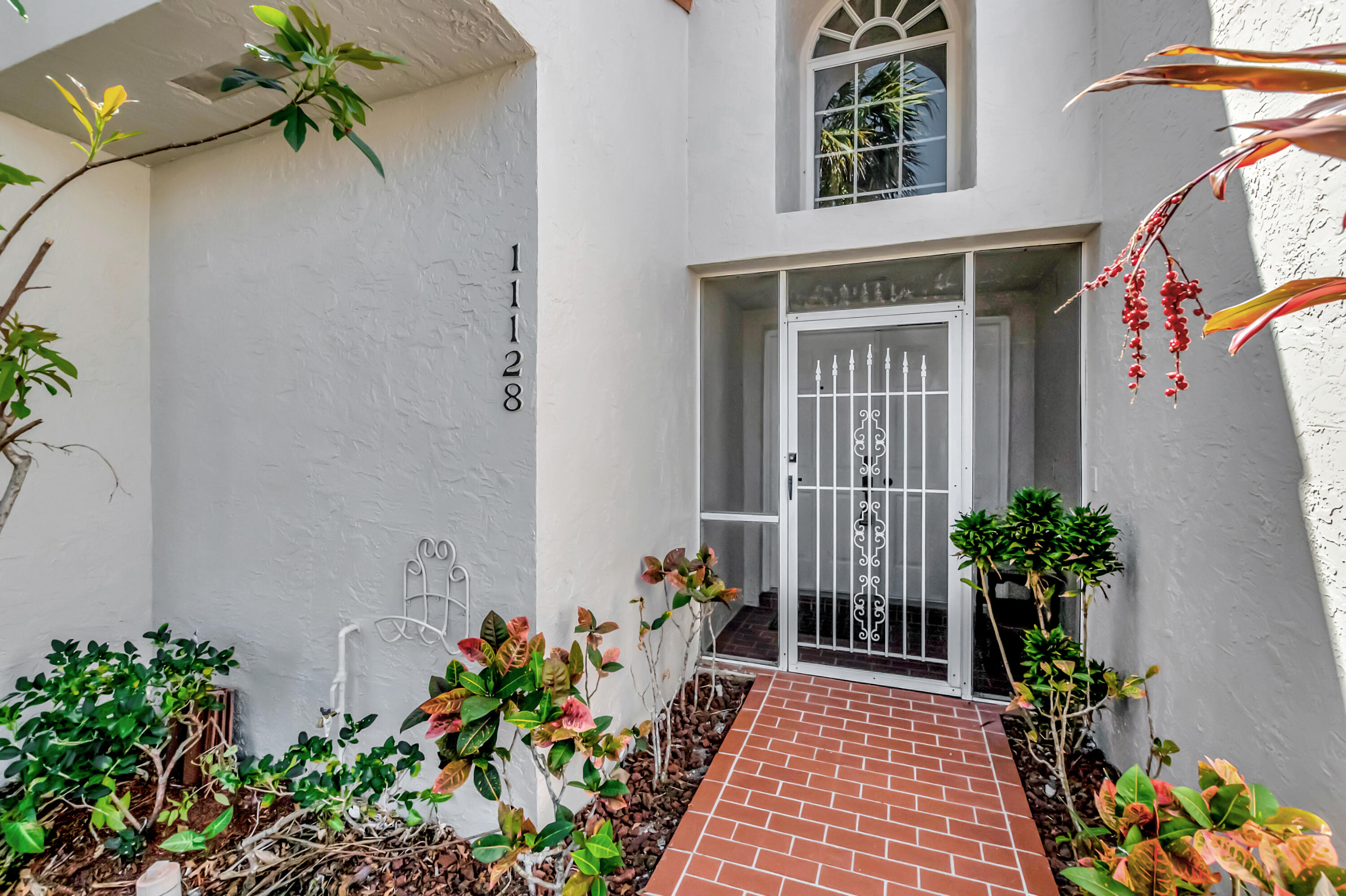 11128 Rios Road Boca Raton, FL 33498 - Photo 5 of 45 a potted plant sitting in front of a house