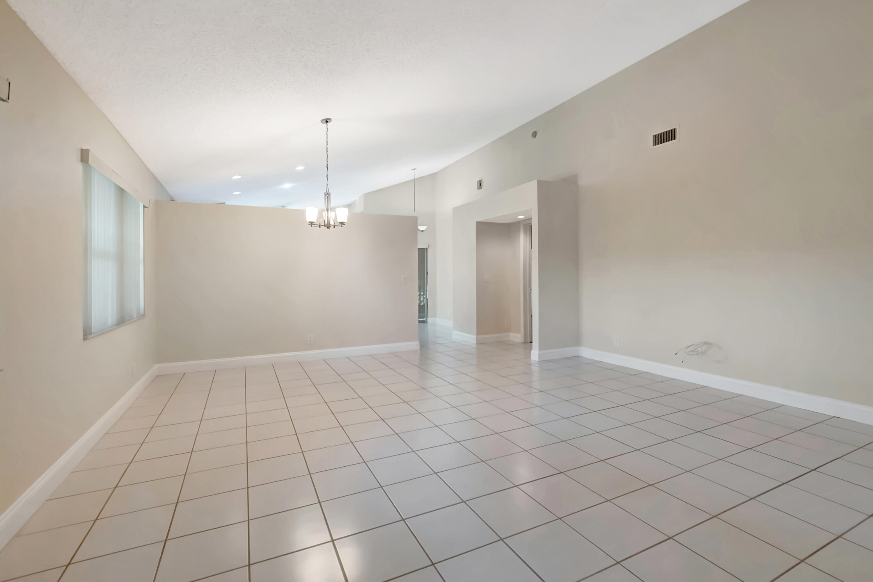 11128 Rios Road Boca Raton, FL 33498 - Photo 10 of 45 an empty room with kitchen and chandelier fan