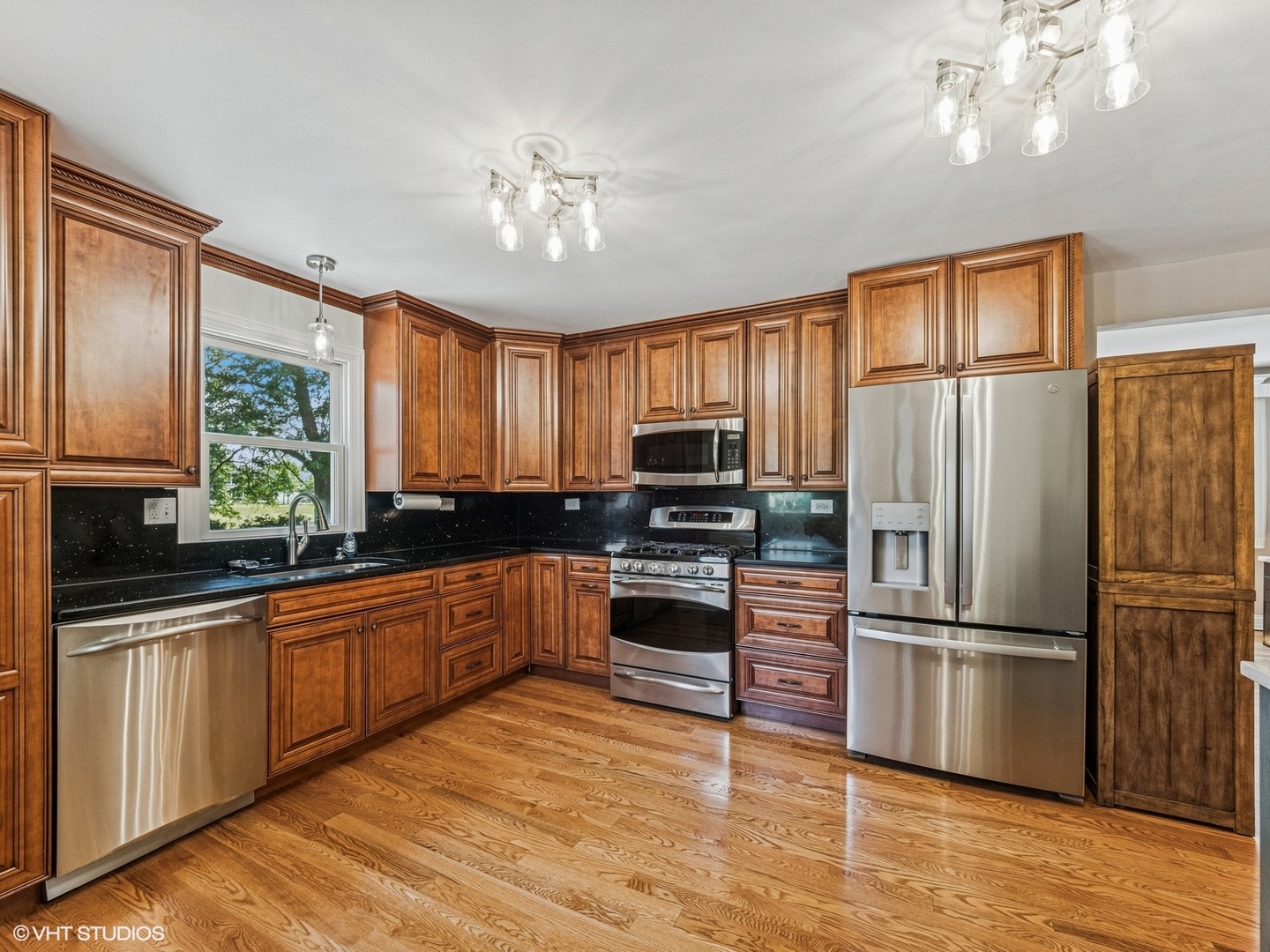 651 Garth Road Wheeling, IL 60090 - Photo 5 of 24 a kitchen with stainless steel appliances granite countertop a refrigerator a stove a sink dishwasher a microwave oven with cabinets and wooden floor