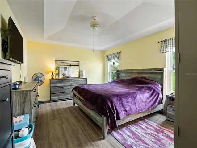 a bedroom with a bed and flat tv screen on dresser