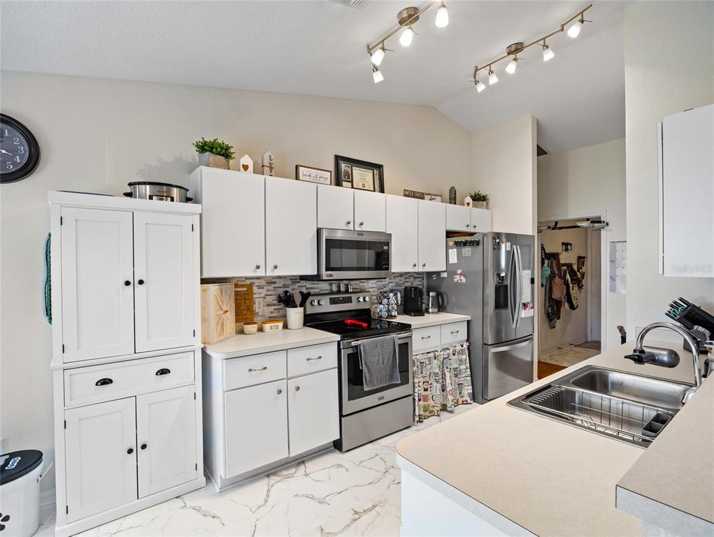 6724 Cherry Road Ocala, FL 34472 - Photo 9 of 29 a kitchen with white cabinets and stainless steel appliances