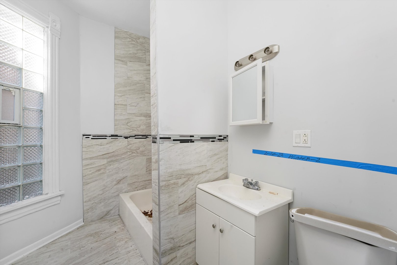 58 West 72nd Street Chicago, IL 60621 - Photo 21 of 28 a bathroom with a sink a toilet and a shower
