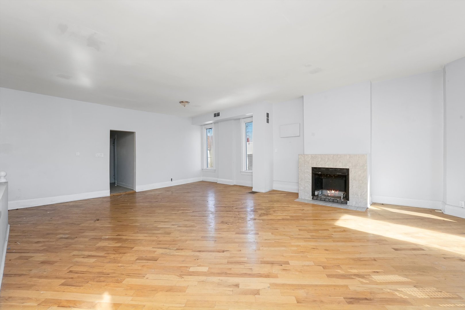 58 West 72nd Street Chicago, IL 60621 - Photo 25 of 28 a view of empty room with wooden floor and fireplace