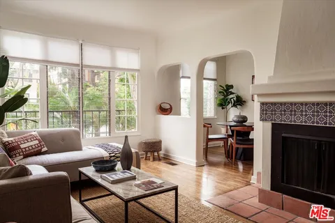 a living room with furniture a fireplace and a floor to ceiling window