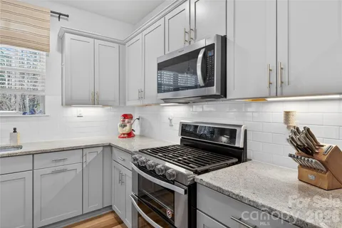 a kitchen with cabinets appliances and a window