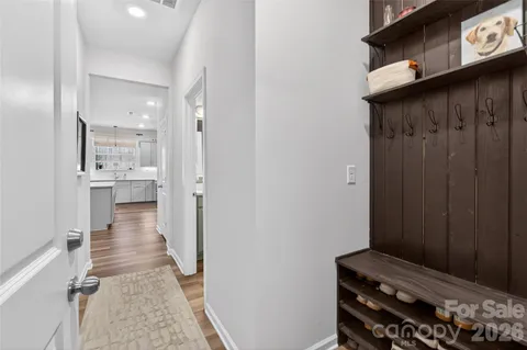 a view of a hallway with wooden floor and staircase