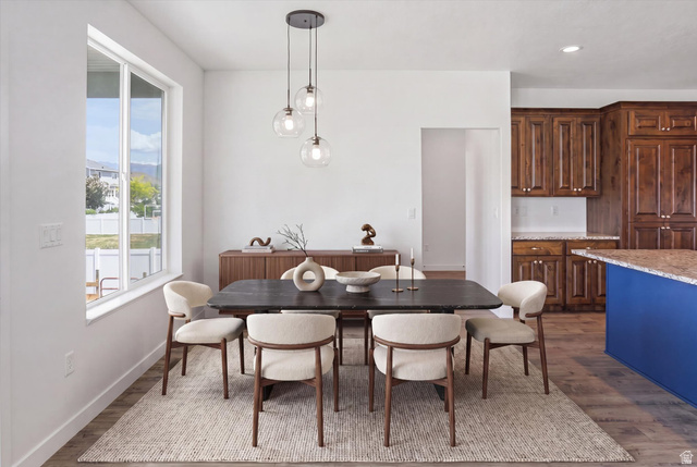 3636 West 910 South Syracuse, UT 84075 - Photo 15 of 70 Dining area featuring a contemporary linear chandelier with clear glass globes, large window with white trim, and wood-finish flooring