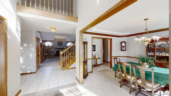 a dining room with furniture a chandelier and window