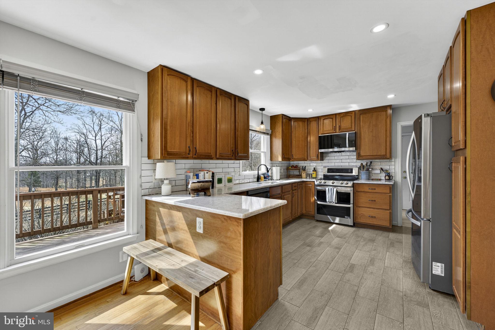10507 Cliff Mills Road Marshall, VA 20115 - Photo 15 of 56 a kitchen with a refrigerator a stove top oven a sink dishwasher and wooden cabinets