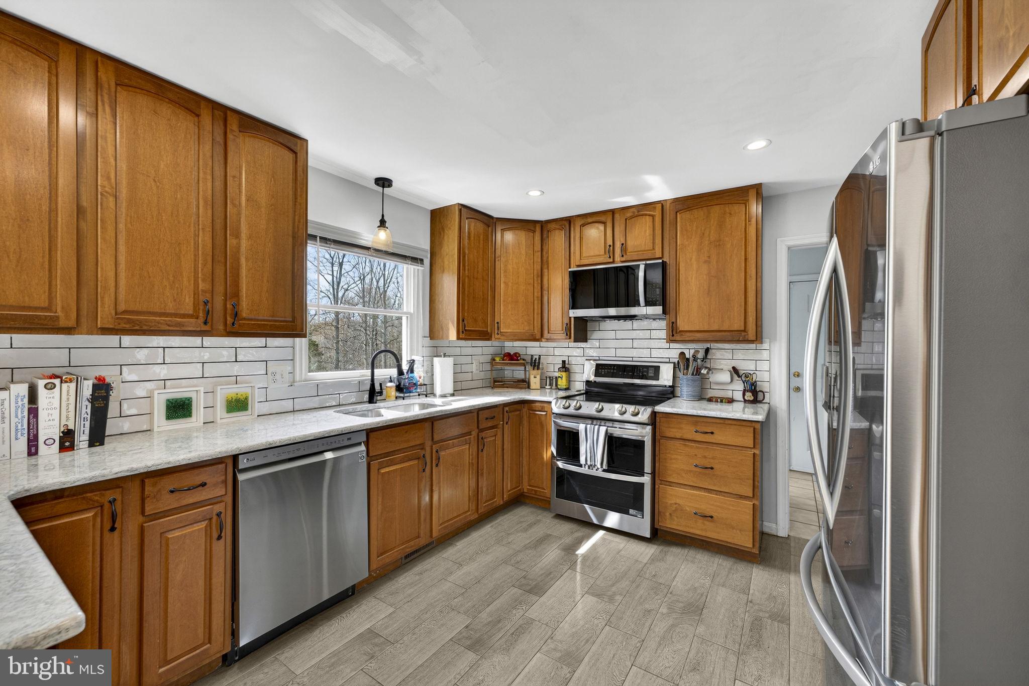 10507 Cliff Mills Road Marshall, VA 20115 - Photo 17 of 56 a kitchen with stainless steel appliances granite countertop a stove top oven a sink dishwasher a refrigerator and cabinets with wooden floor