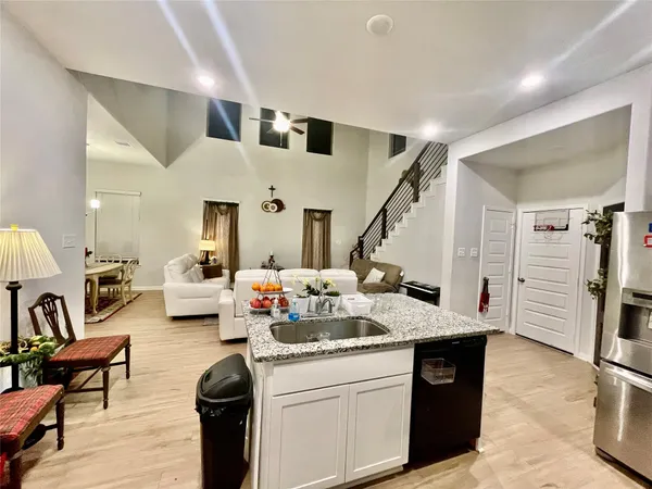 a open kitchen with stainless steel appliances kitchen island granite countertop a refrigerator and a stove