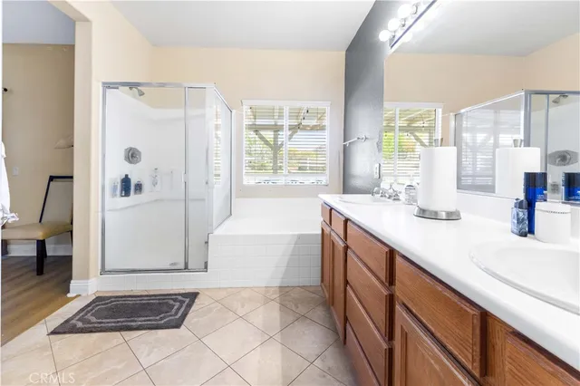 a bathroom with a tub a sink and a large mirror