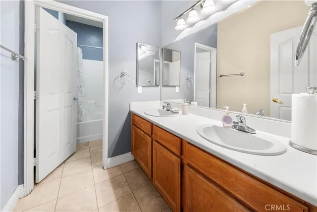 a spacious bathroom with a double vanity sink a mirror and a shower