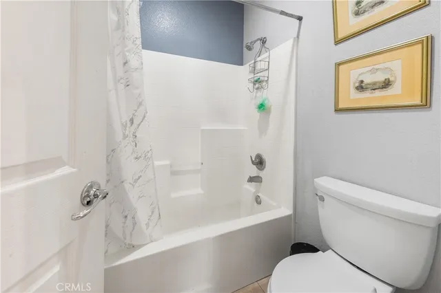 a white toilet sitting next to a bath tub