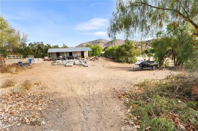 a view of a backyard of a house with table and chairs under an umbrella
