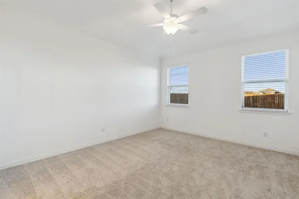 an empty room with a window and a ceiling fan