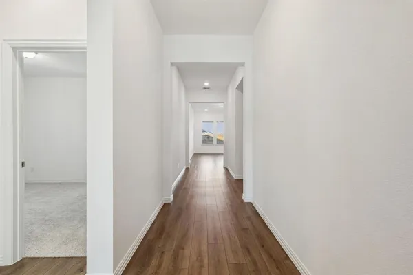 a view of a hallway with wooden floor