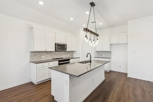 a kitchen with a sink a stove a refrigerator and a chandelier