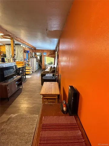 a backyard of a house with large trees and outdoor seating